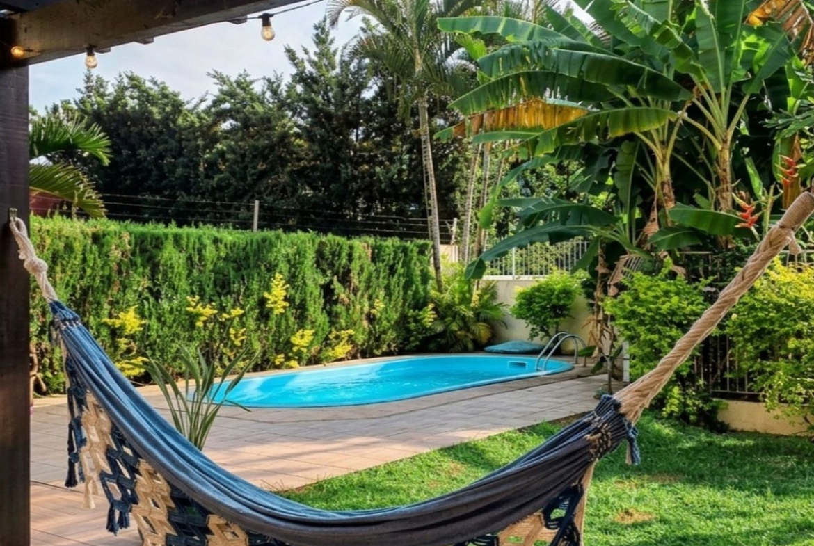 Área de lazer com piscina e jardim em casa a venda no Parque São Jorge, Florianópolis.