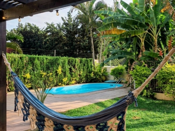 Área de lazer com piscina e jardim em casa a venda no Parque São Jorge, Florianópolis.
