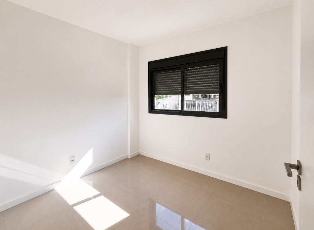 Quarto com piso em porcelanato, portas laqueadas Pormade e janela de alumínio com persiana de enrolar na Trindade.