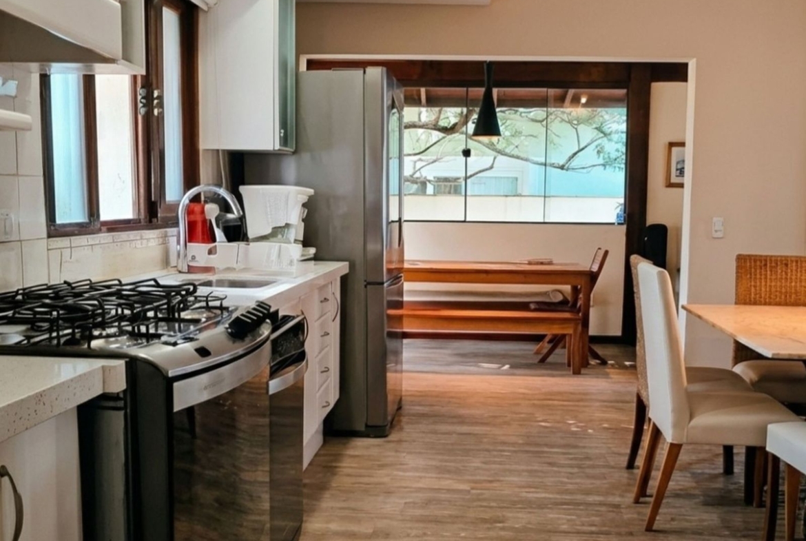 Cozinha planejada com vista para área de lazer, em casa no Parque São Jorge, Florianópolis.