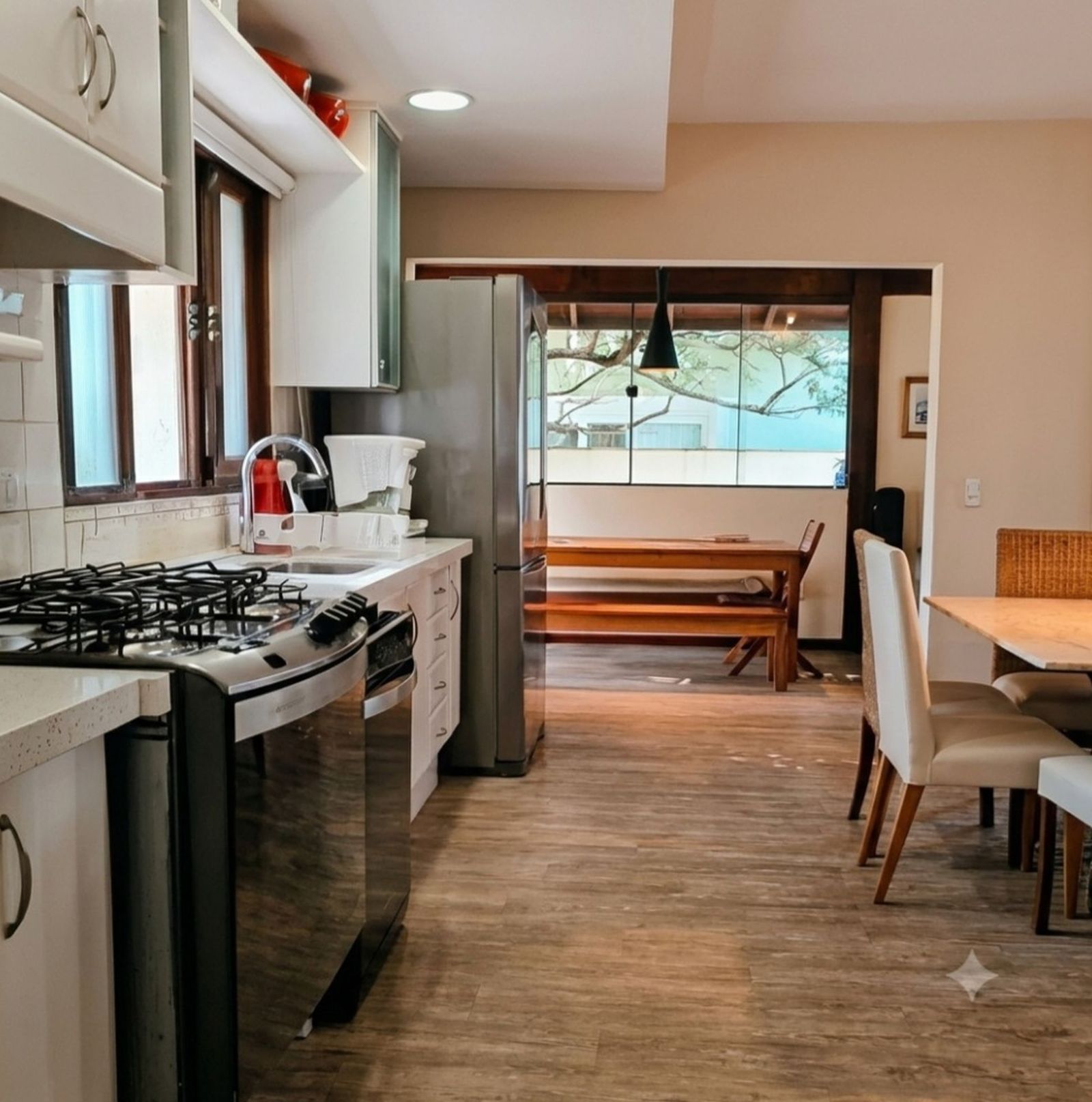 Cozinha planejada com vista para área de lazer, em casa no Parque São Jorge, Florianópolis.