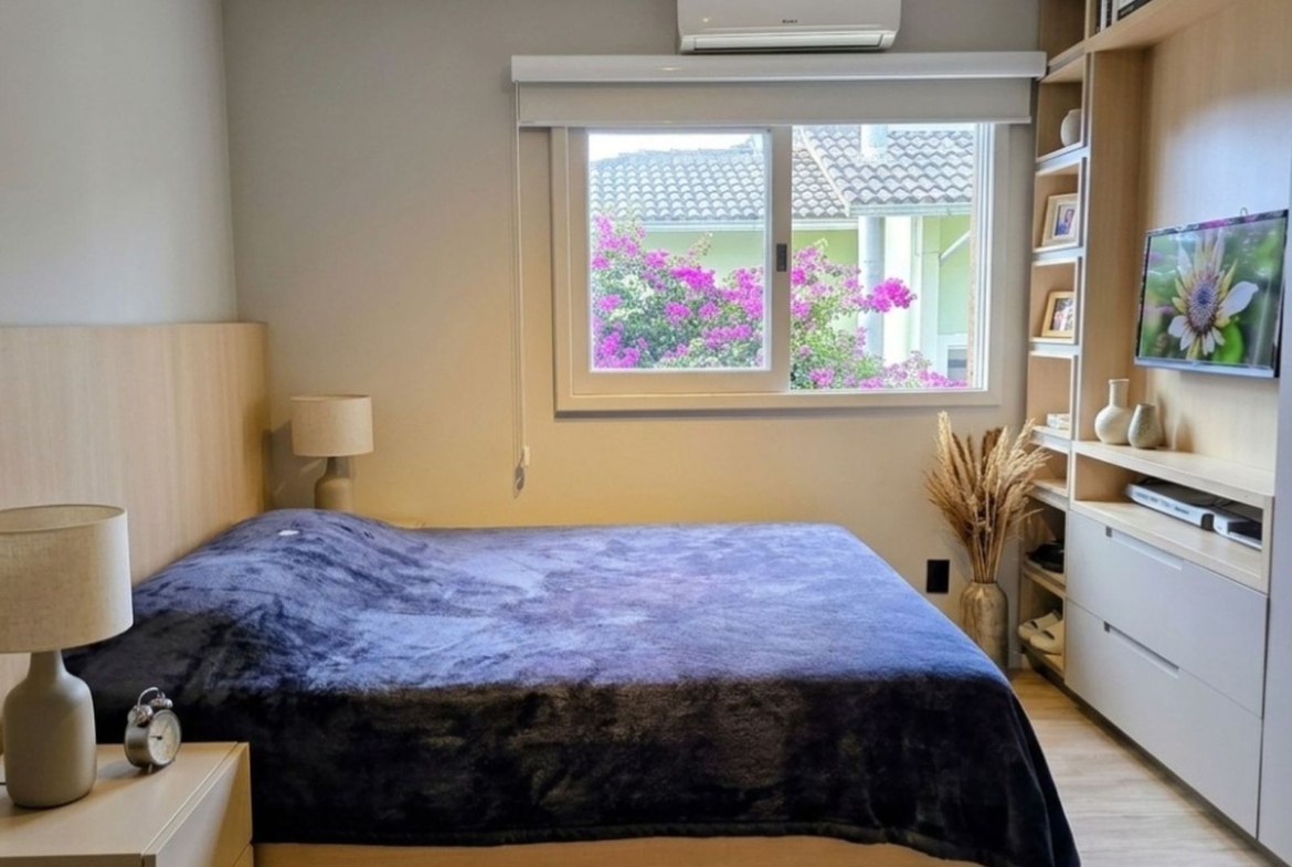 Dormitório aconchegante com móveis planejados, excelente iluminação natural e split, no Itacorubi.