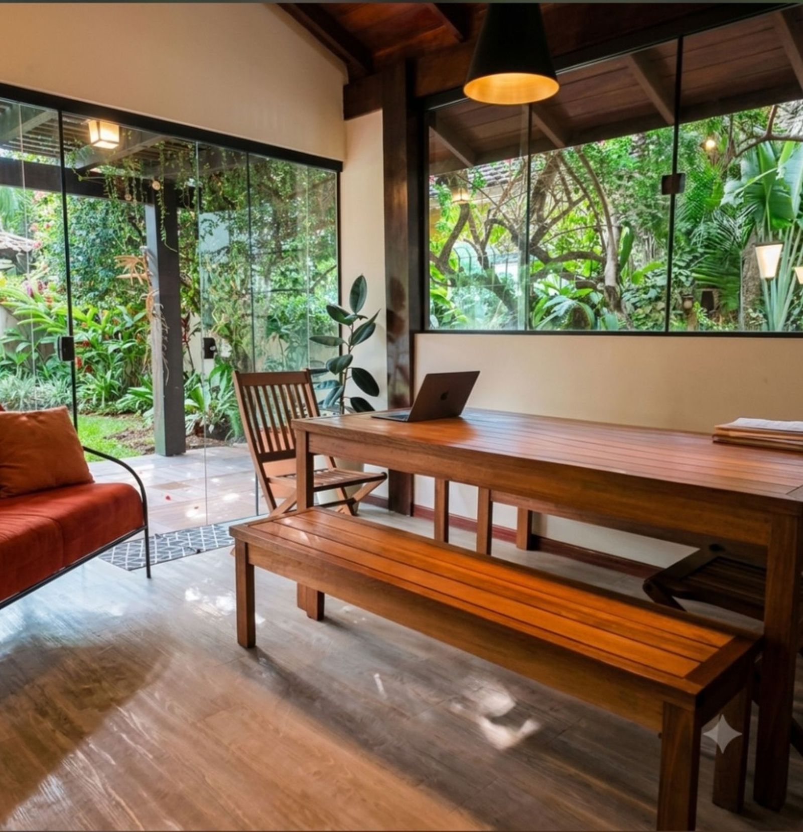 Copa integrada à varanda gourmet com churrasqueira, gramado e piscina em casa no Parque São Jorge, Florianópolis.