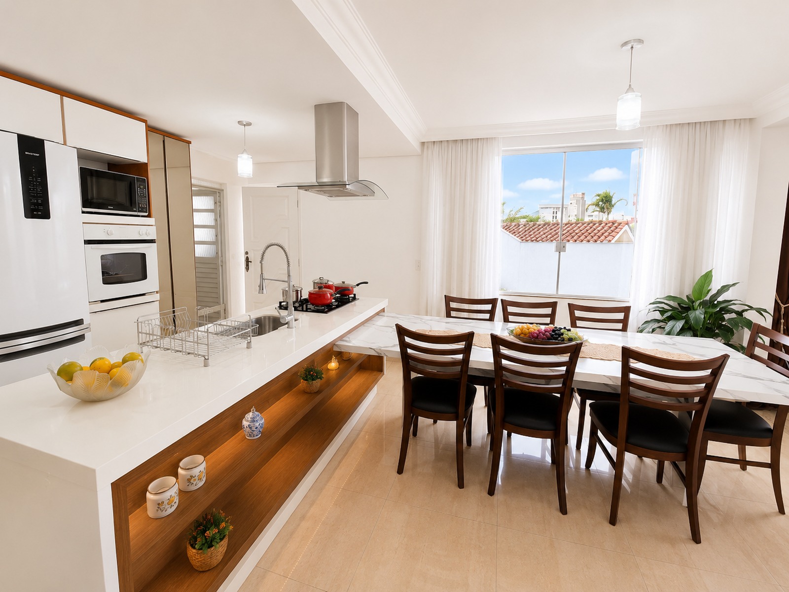 Cozinha americana planejada com ilha central e bancada, integrada à sala de jantar em residência no bairro agronômica em Florianópolis.