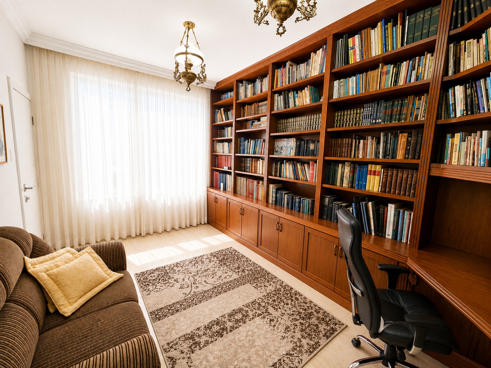 Escritório residencial com ampla biblioteca em madeira, bancada de trabalho e iluminação natural em casa em Florianópolis.