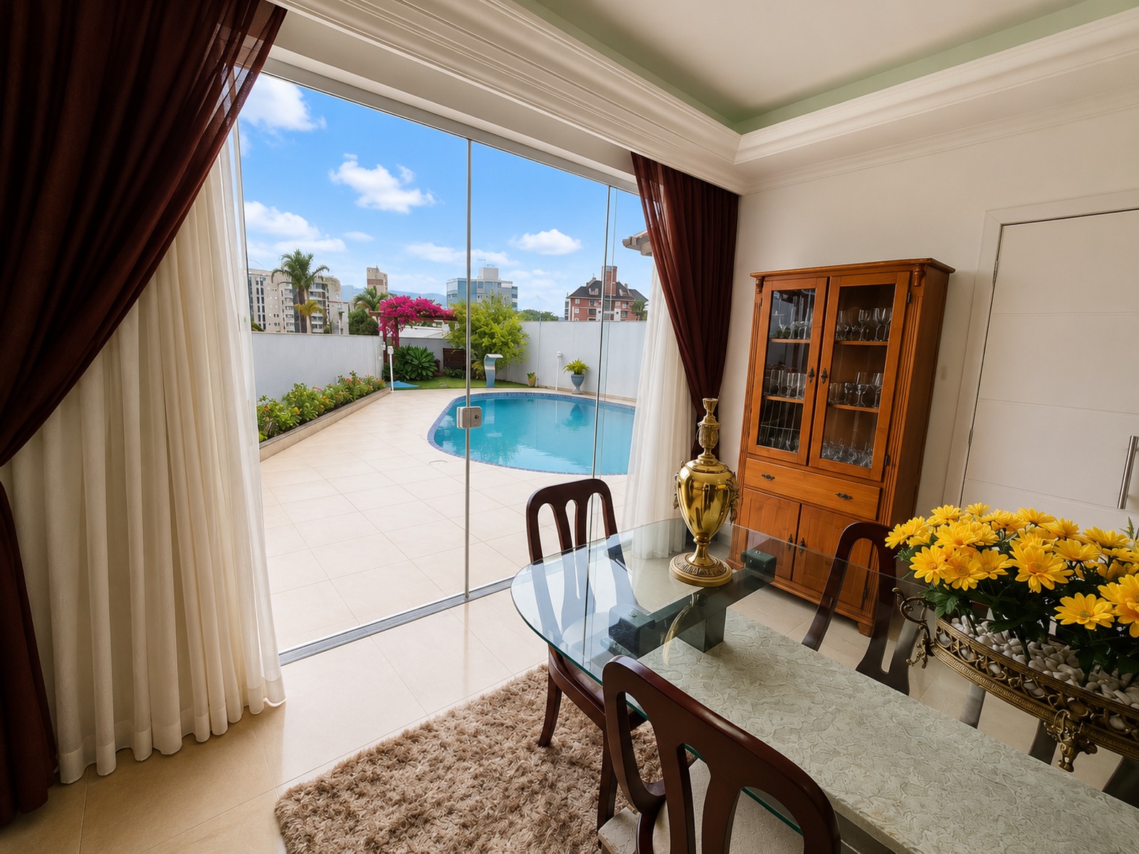 Sala de jantar com comunicação direta com a área de solarium da piscina e área de churrasqueira, casa à venda em Florianópolis.